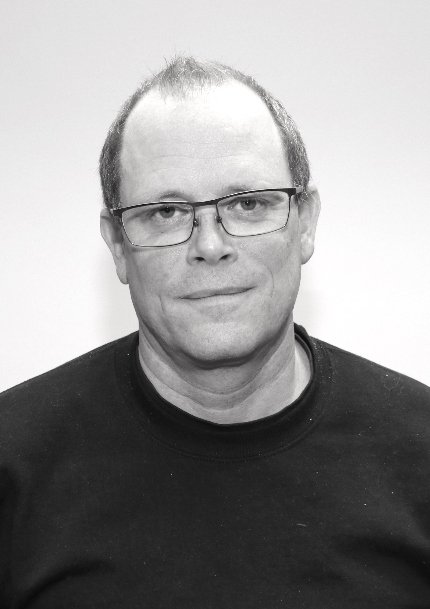 Ett svartvitt foto av en man som bär glasögon.