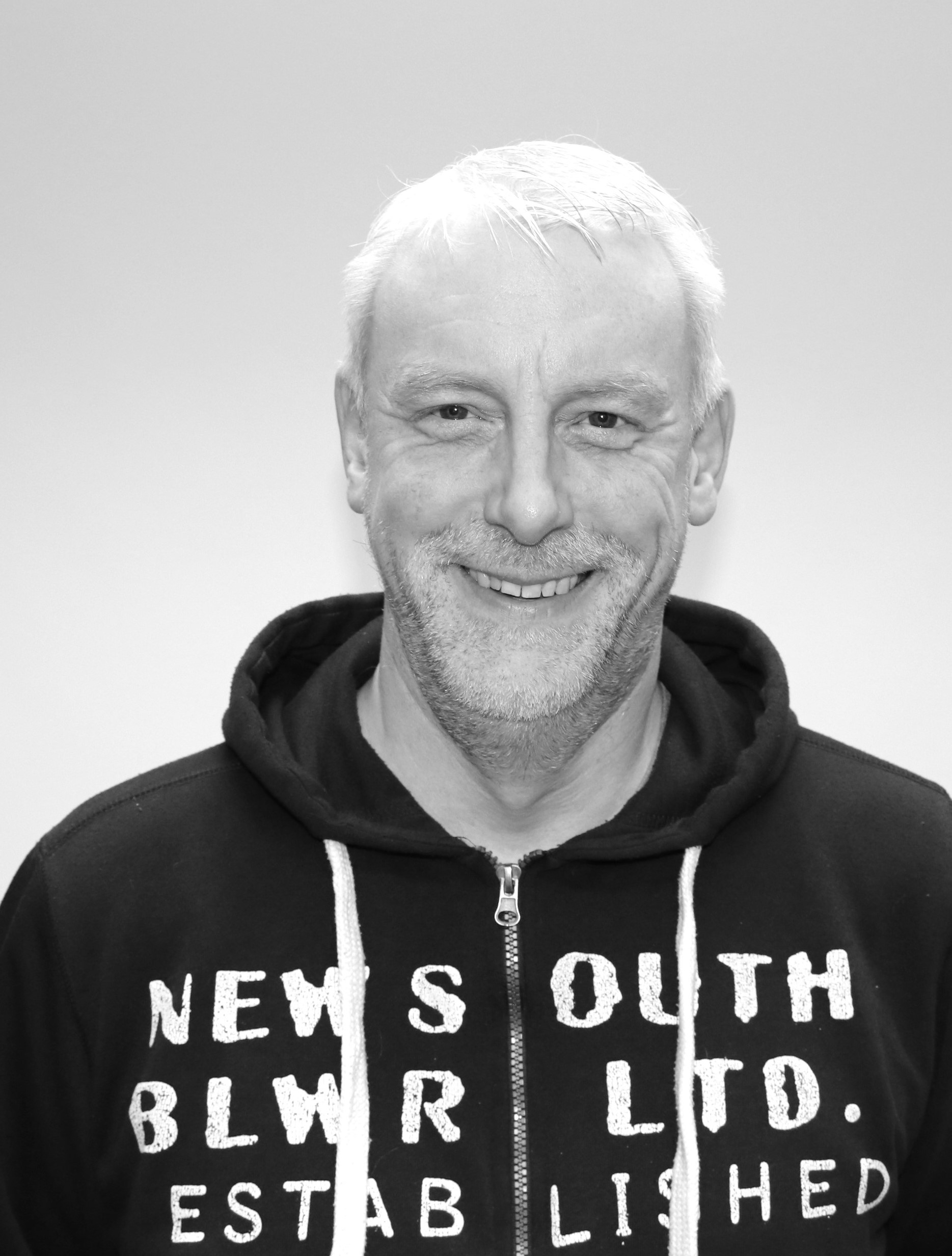 Ett svartvitt foto av en man som bär en hoodie.