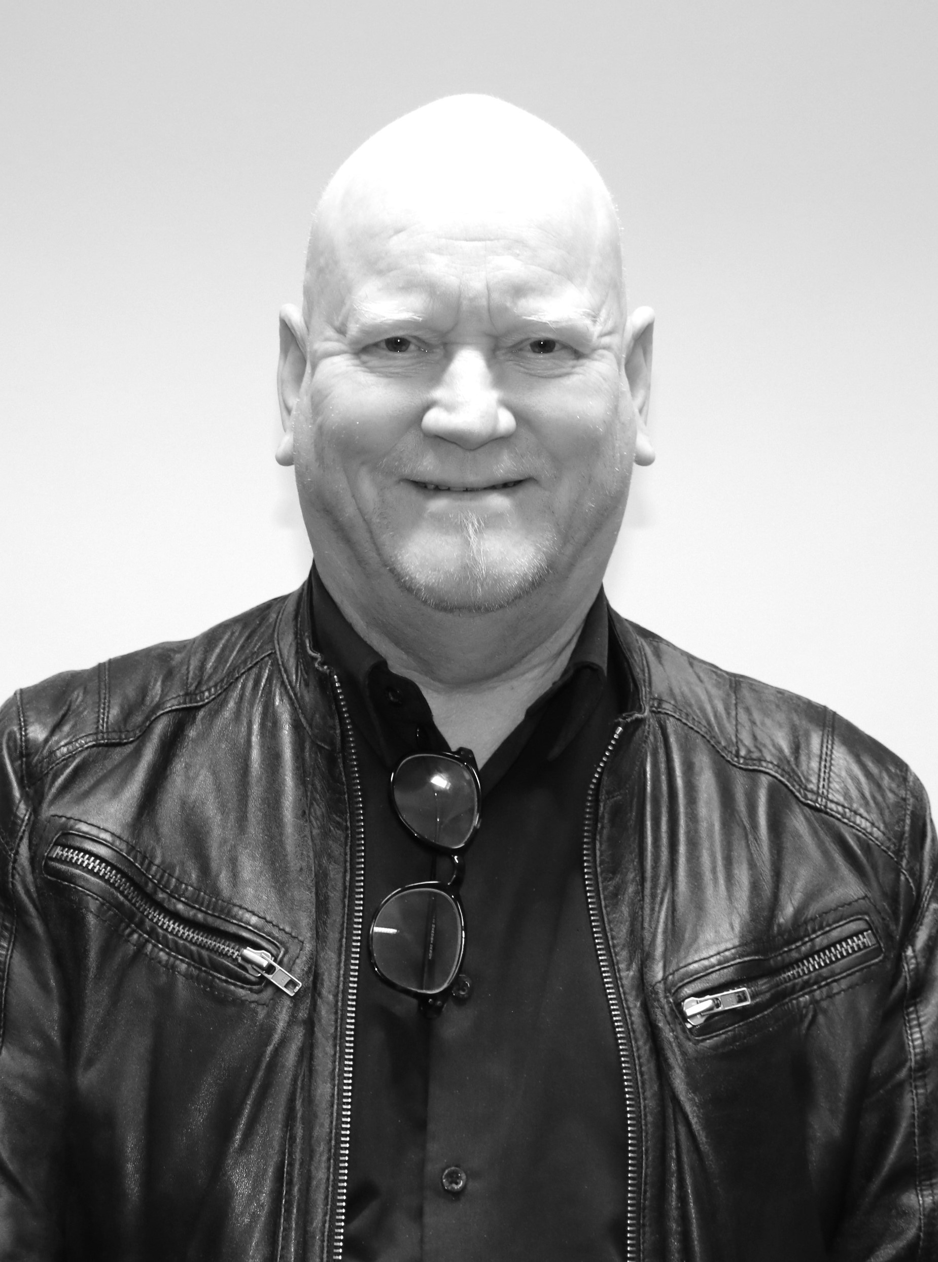 Ett svartvitt foto av en skallig man i en skinnjacka.